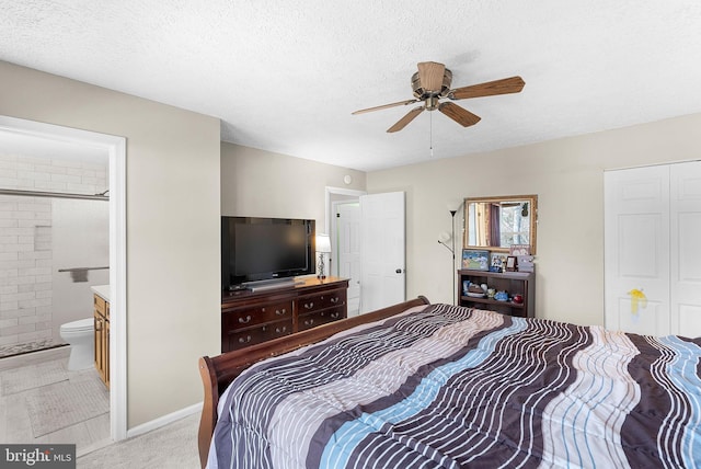 bedroom with baseboards, ceiling fan, light carpet, a textured ceiling, and ensuite bath