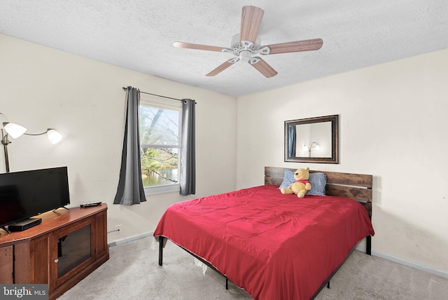 carpeted bedroom featuring baseboards, a textured ceiling, and ceiling fan