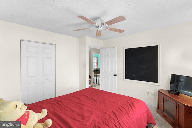 bedroom with a closet, ceiling fan, a textured ceiling, and carpet