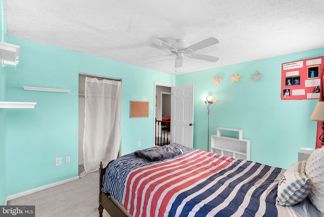 carpeted bedroom with baseboards, a textured ceiling, and ceiling fan