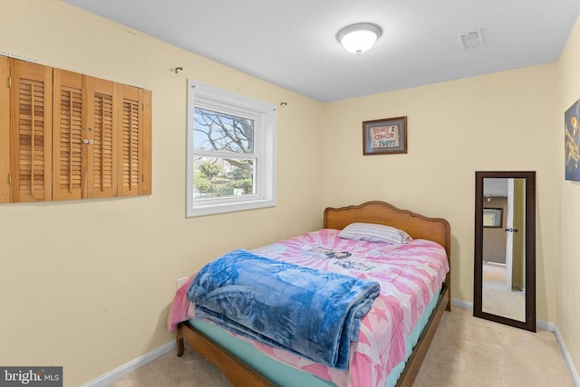 carpeted bedroom featuring visible vents and baseboards