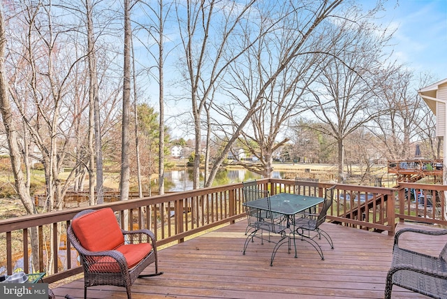 wooden deck with outdoor dining area and a water view