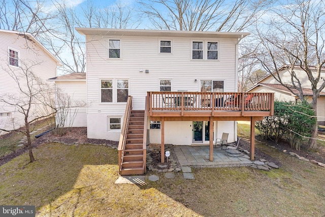 back of property with a wooden deck, a patio, a yard, and stairs