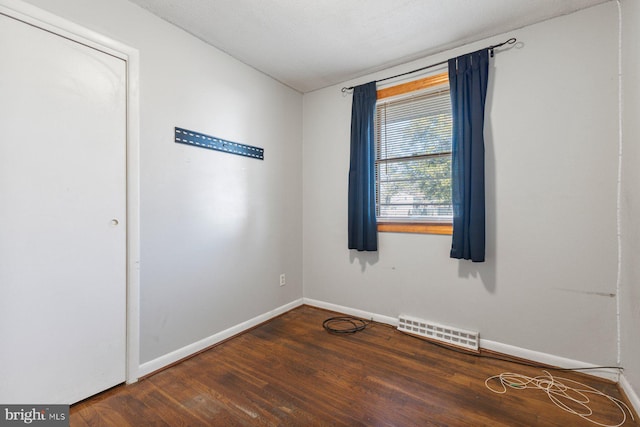 spare room with visible vents, baseboards, and wood finished floors