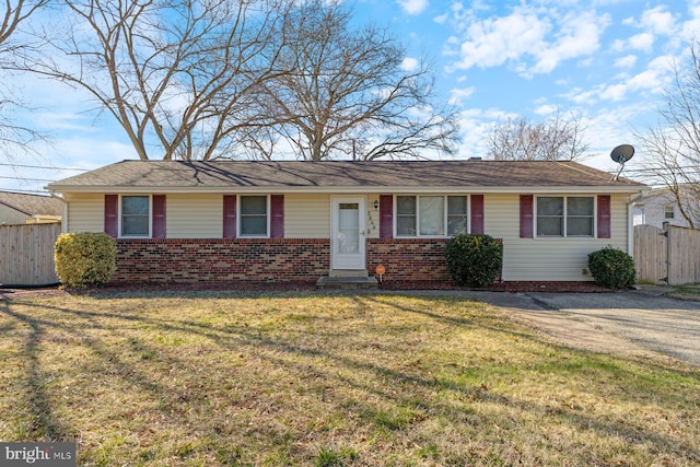 ranch-style home with brick siding, a gate, a front yard, and fence