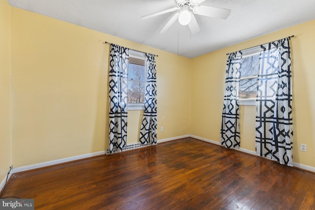 empty room featuring baseboards, wood-type flooring, and a ceiling fan