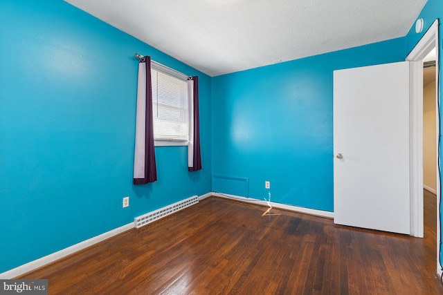 empty room with hardwood / wood-style floors, baseboards, and visible vents