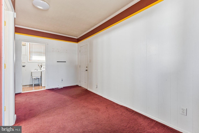 unfurnished room featuring crown molding and dark carpet