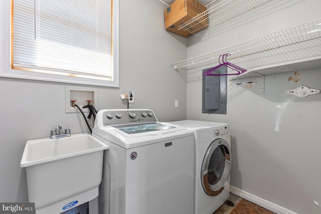 washroom with washer and clothes dryer, electric panel, a sink, baseboards, and laundry area