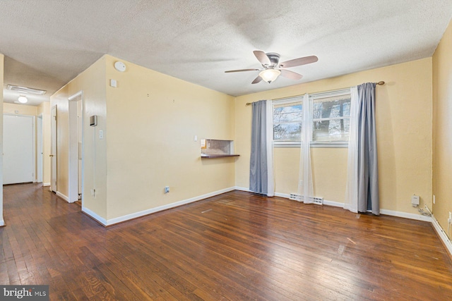 unfurnished room featuring visible vents, a ceiling fan, a textured ceiling, wood-type flooring, and baseboards