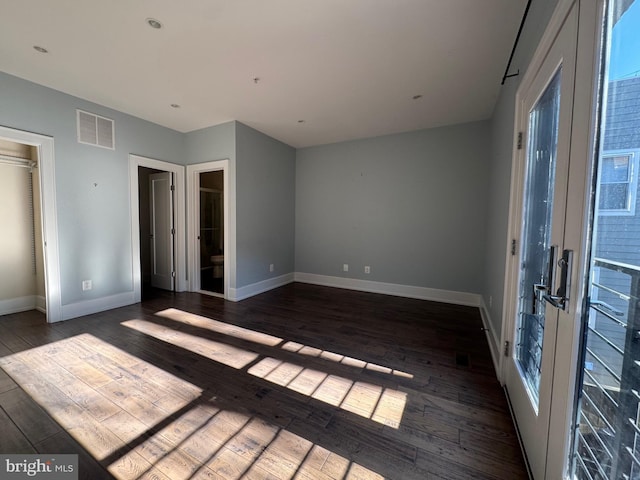 unfurnished bedroom with visible vents, baseboards, french doors, and hardwood / wood-style flooring