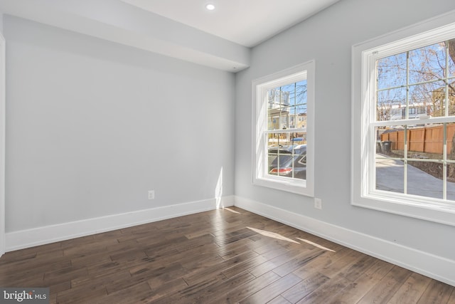 spare room featuring dark wood finished floors, recessed lighting, and baseboards