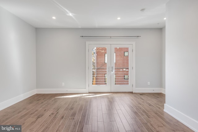 spare room with recessed lighting, french doors, baseboards, and wood finished floors