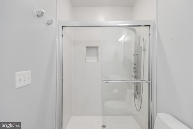 bathroom with a shower stall and toilet