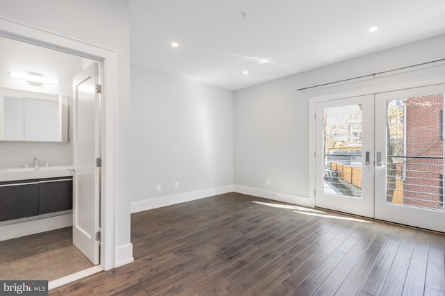 unfurnished room featuring a sink, recessed lighting, french doors, baseboards, and dark wood-style flooring