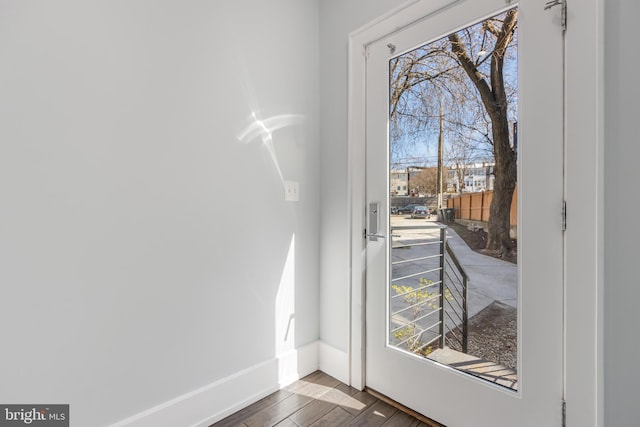 doorway to outside featuring dark wood finished floors and baseboards