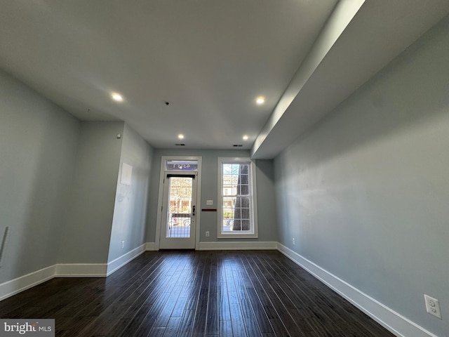 spare room with recessed lighting, baseboards, and dark wood-style floors