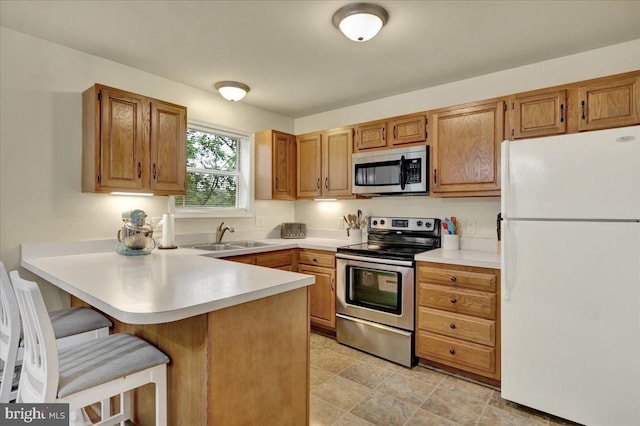 5 Westpointe Dr, Ephrata, PA 17522 - kitchen with appliances with stainless steel finishes, a sink, a peninsula, light countertops, and a kitchen bar