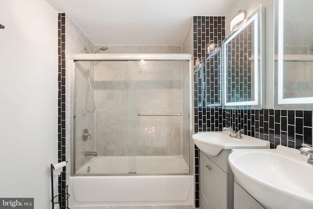 full bathroom with enclosed tub / shower combo, backsplash, vanity, and tile walls