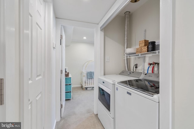 clothes washing area featuring separate washer and dryer, baseboards, and light carpet