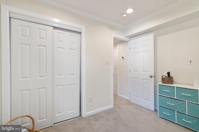 bedroom with light colored carpet, baseboards, a closet, and ornamental molding