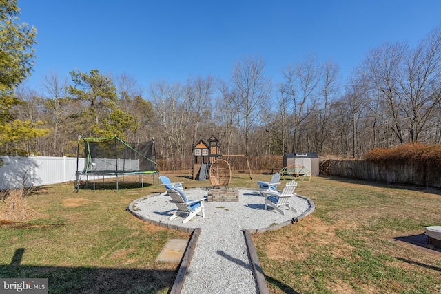 view of yard featuring a fenced backyard, an outdoor structure, a storage shed, a playground, and a trampoline