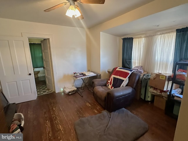 living area with a ceiling fan and wood finished floors