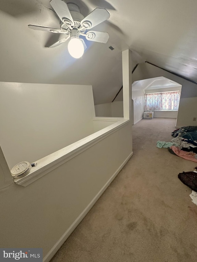 hallway featuring an upstairs landing, visible vents, carpet, and lofted ceiling