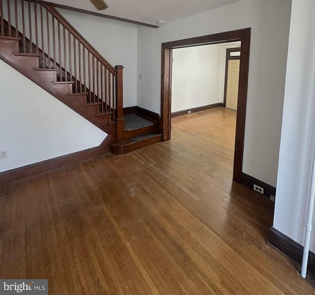 interior space featuring baseboards, wood finished floors, and stairs