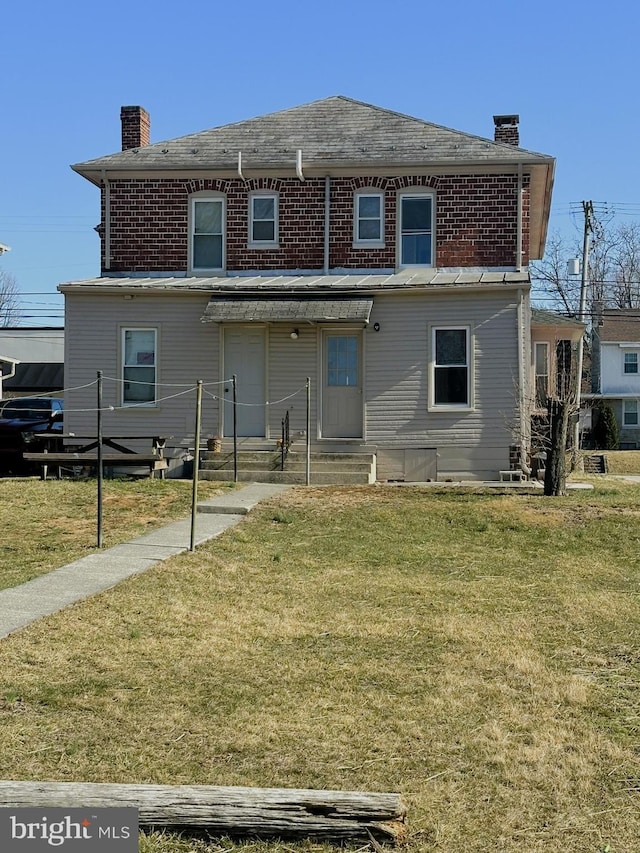 exterior space with a lawn, brick siding, and a chimney