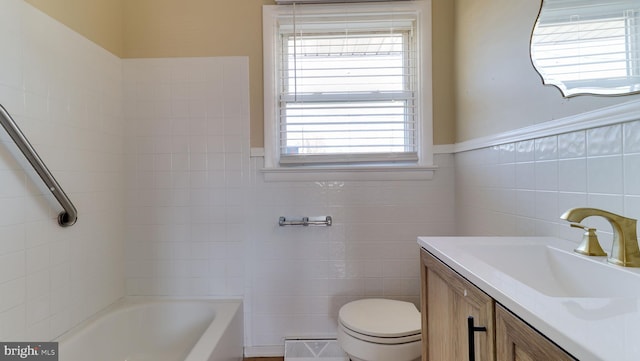 bathroom with vanity, a wainscoted wall, tile walls, toilet, and baseboard heating