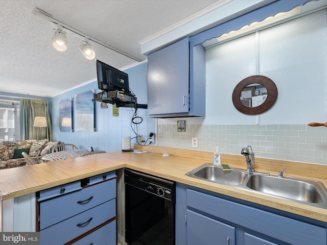 kitchen with a peninsula, black dishwasher, blue cabinets, and a sink