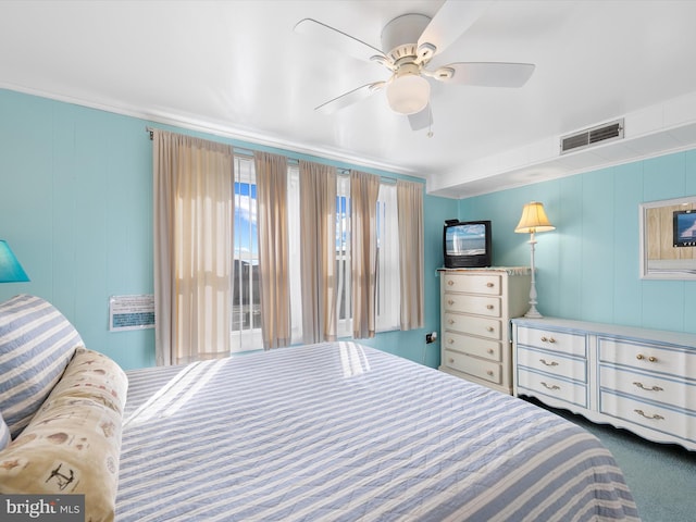 bedroom featuring a ceiling fan, visible vents, and dark carpet