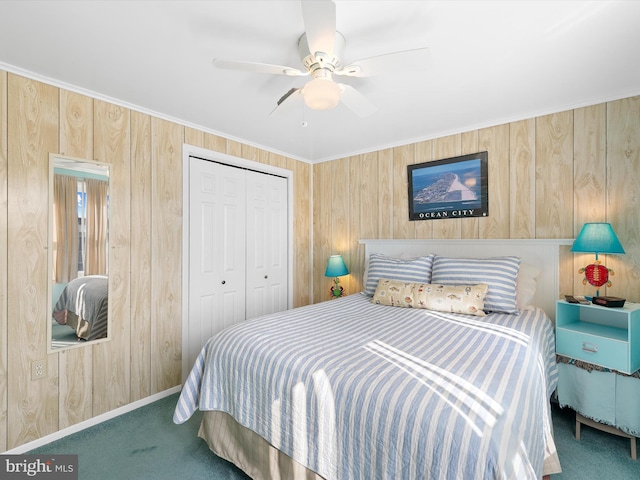 carpeted bedroom featuring wooden walls, a ceiling fan, and a closet