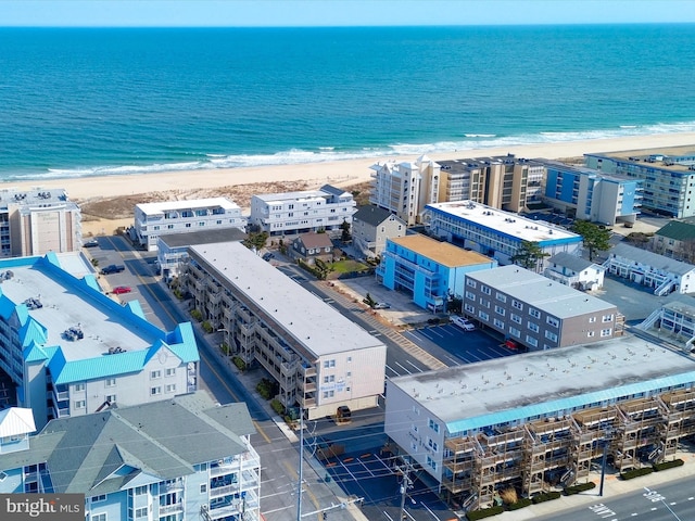 drone / aerial view with a water view and a beach view