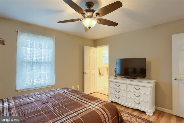 bedroom featuring baseboards, light wood-type flooring, and ceiling fan