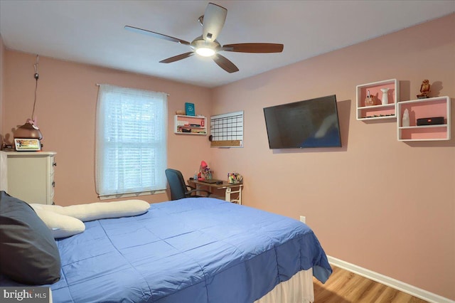 bedroom with ceiling fan, baseboards, and wood finished floors