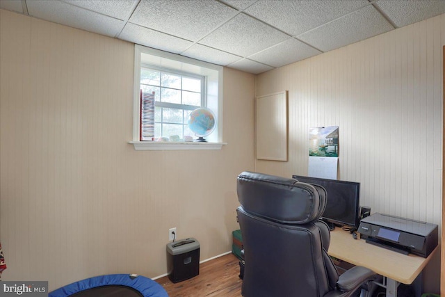 office area featuring baseboards, a paneled ceiling, and wood finished floors