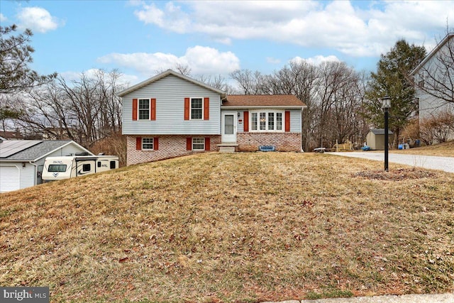 split level home featuring brick siding and a front yard