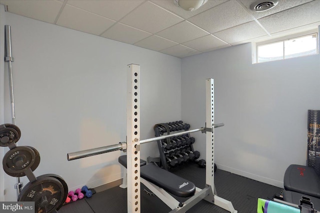 workout room with baseboards, visible vents, and a drop ceiling