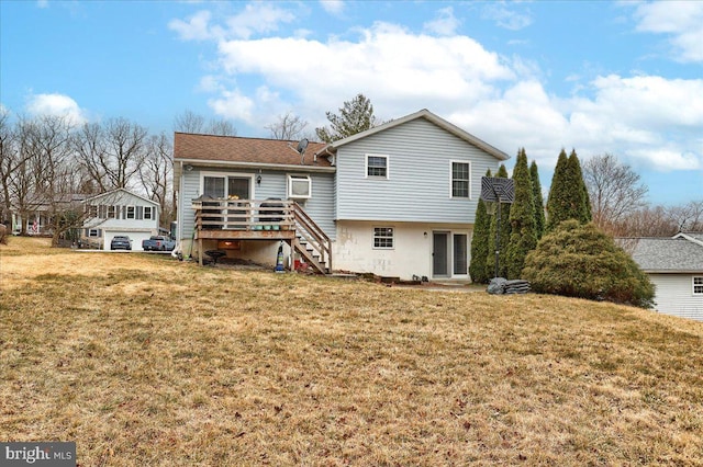 back of property with a yard, a deck, and stairs