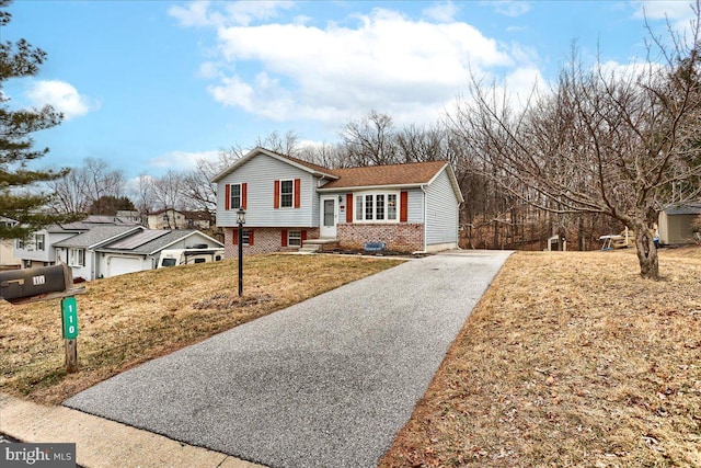 tri-level home with brick siding and driveway