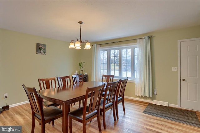 dining room featuring a chandelier, visible vents, light wood-style flooring, and baseboards