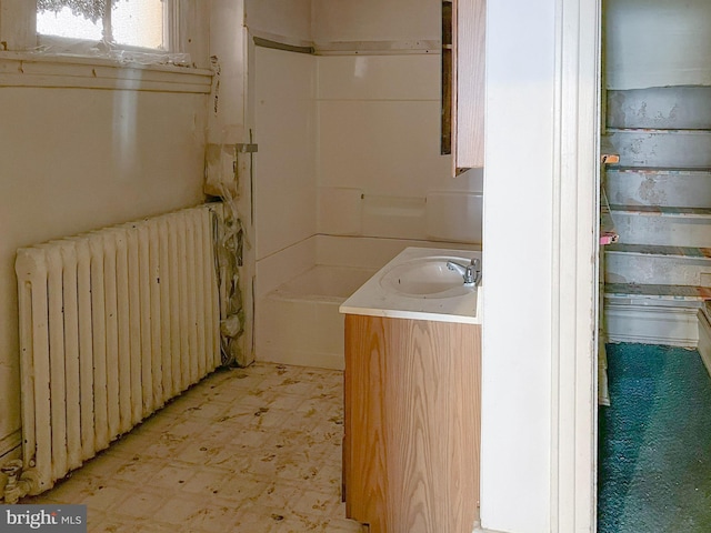 bathroom featuring tile patterned floors, radiator, and a sink