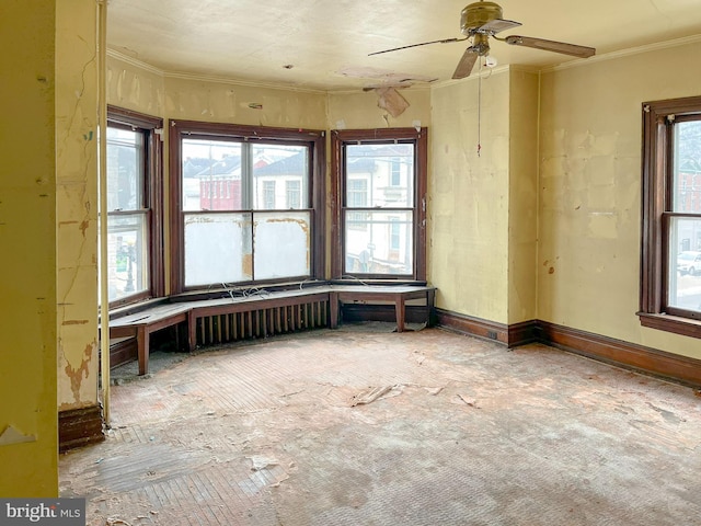 empty room with baseboards, plenty of natural light, and crown molding