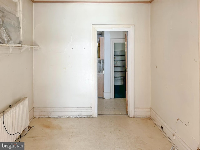 interior space with unfinished concrete floors and radiator