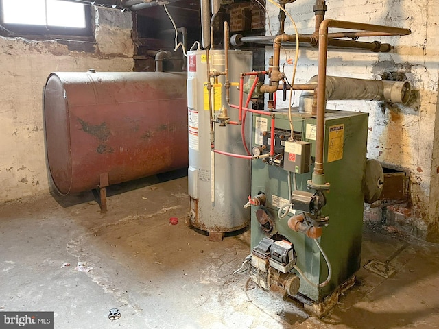 utility room featuring a heating unit, heating fuel, and water heater