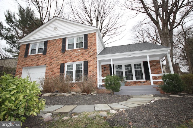 view of front facade featuring an attached garage, covered porch, brick siding, and roof with shingles