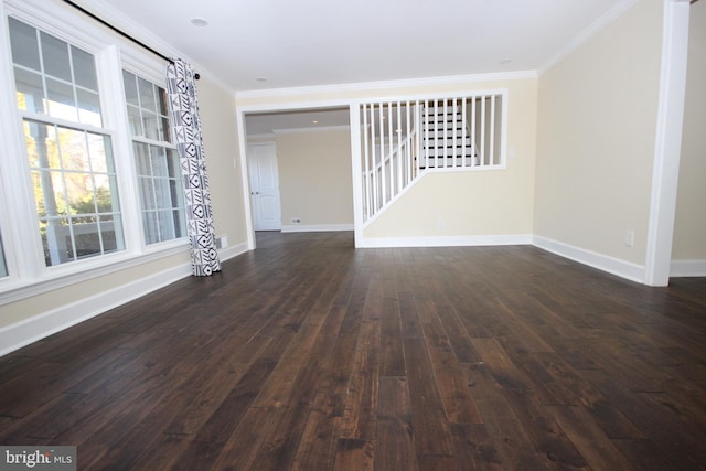 unfurnished living room with dark wood-style floors, baseboards, and ornamental molding