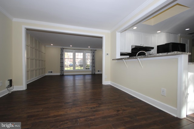 kitchen featuring black fridge, dark wood finished floors, white cabinetry, crown molding, and baseboards